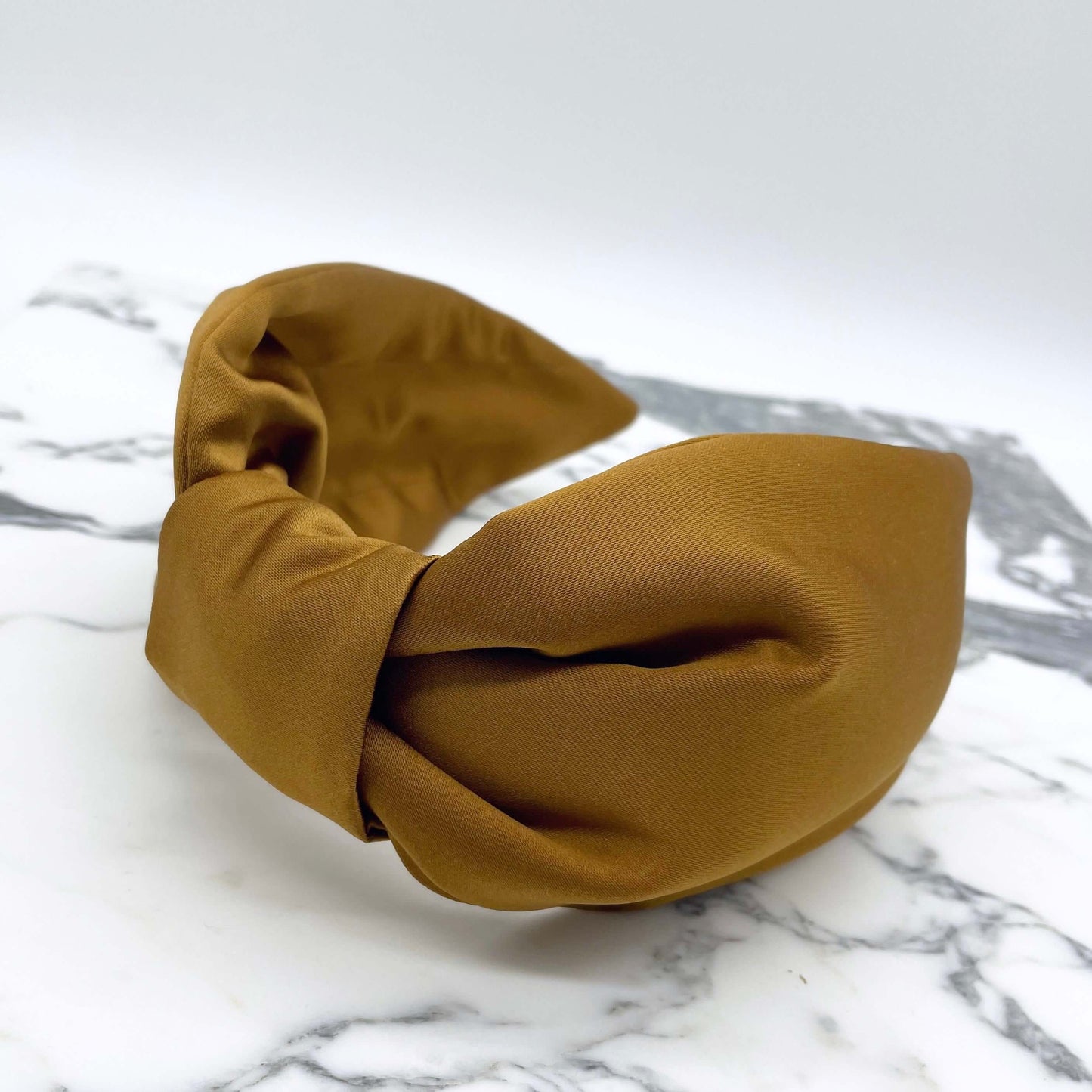 Gold satin knotted headband in a bow style