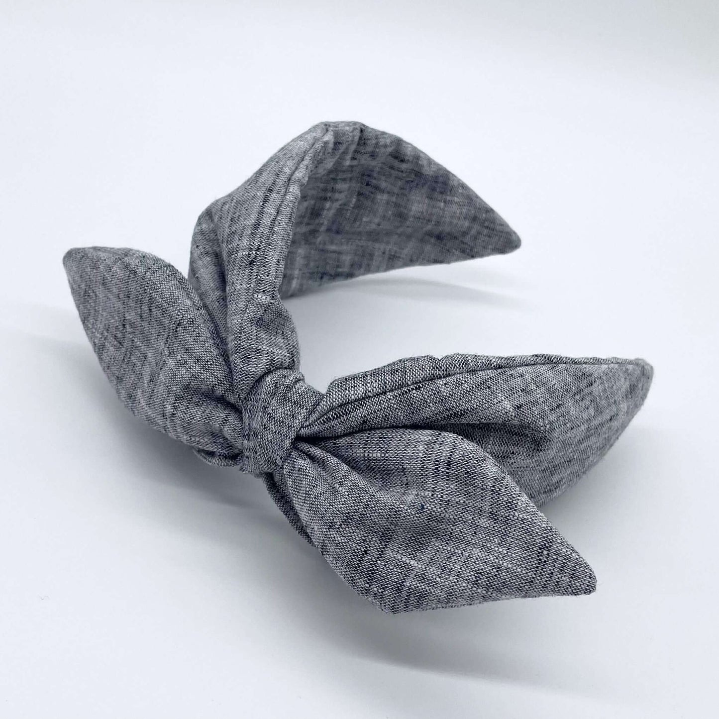 A black coloured linen headban with a bow.