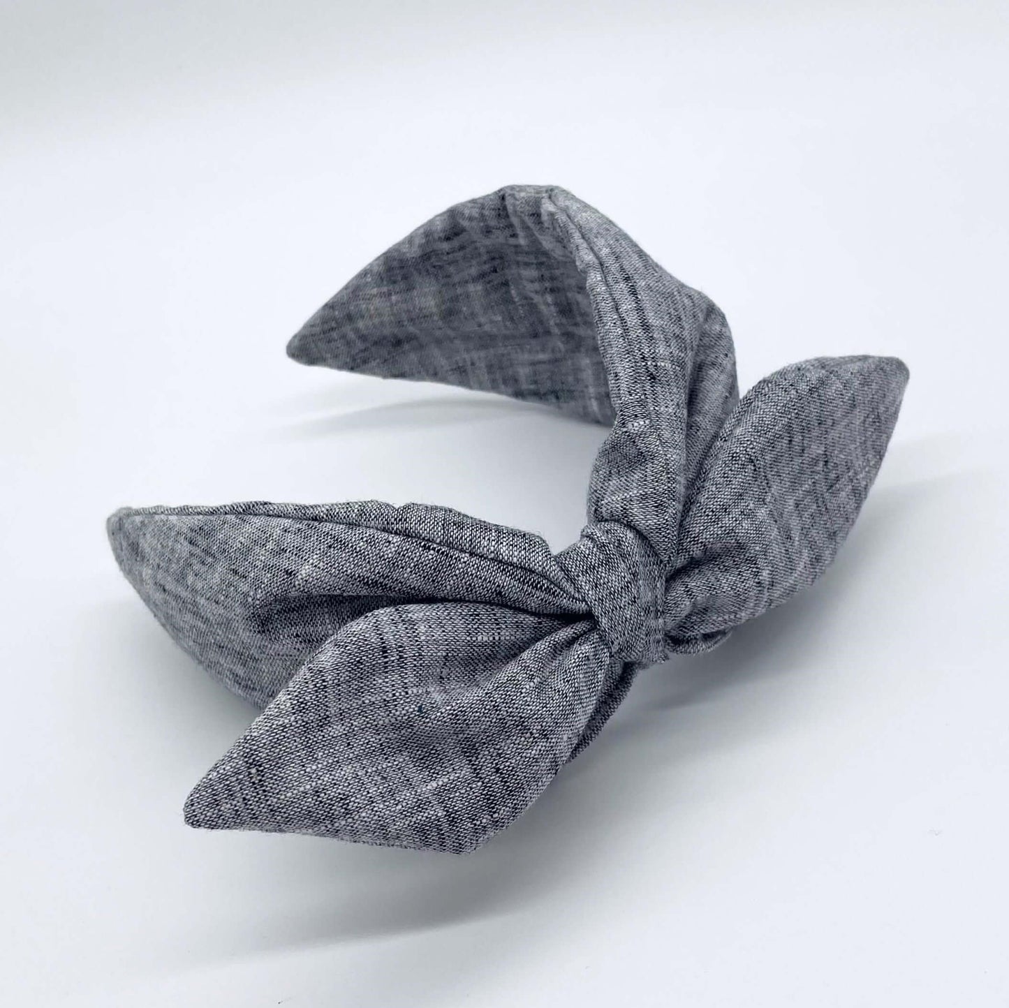 A black coloured linen headban with a bow.