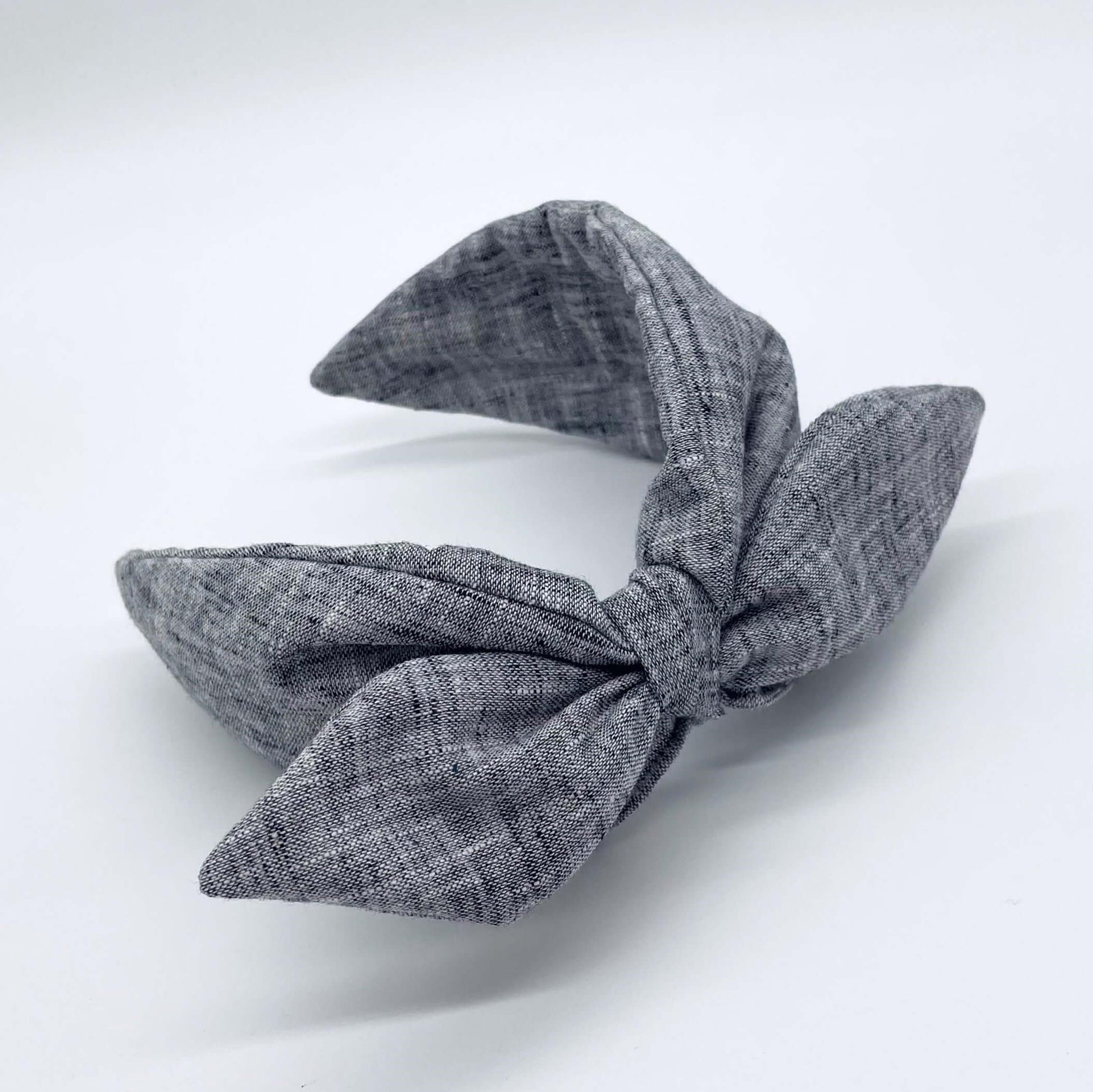 A black coloured linen headban with a bow.