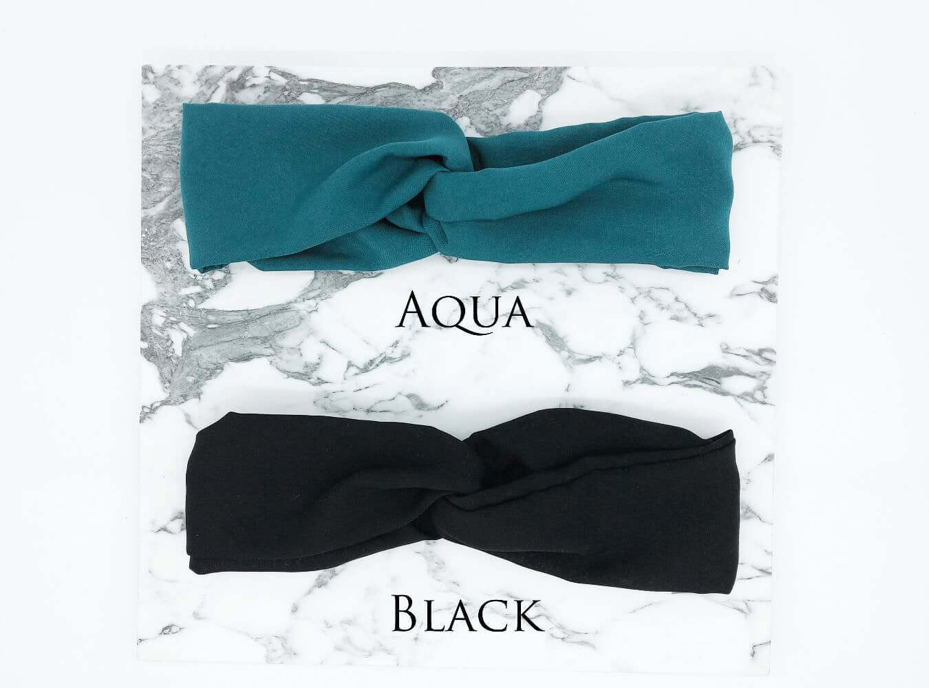 Two soft, viscose, elasticated turban twist headbands in aqua green and black.