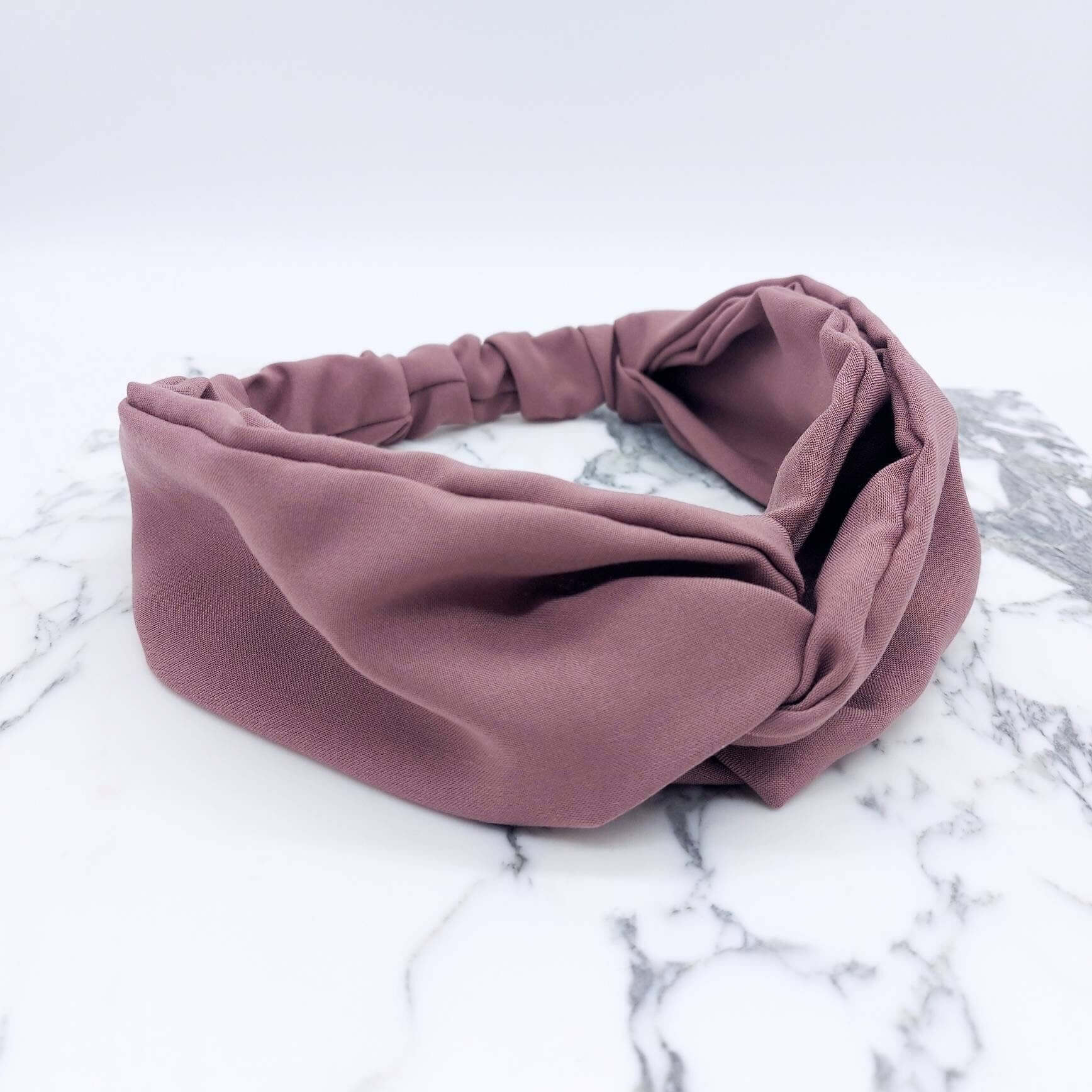 A soft, pale rose, viscose, elasticated turban twist headband.