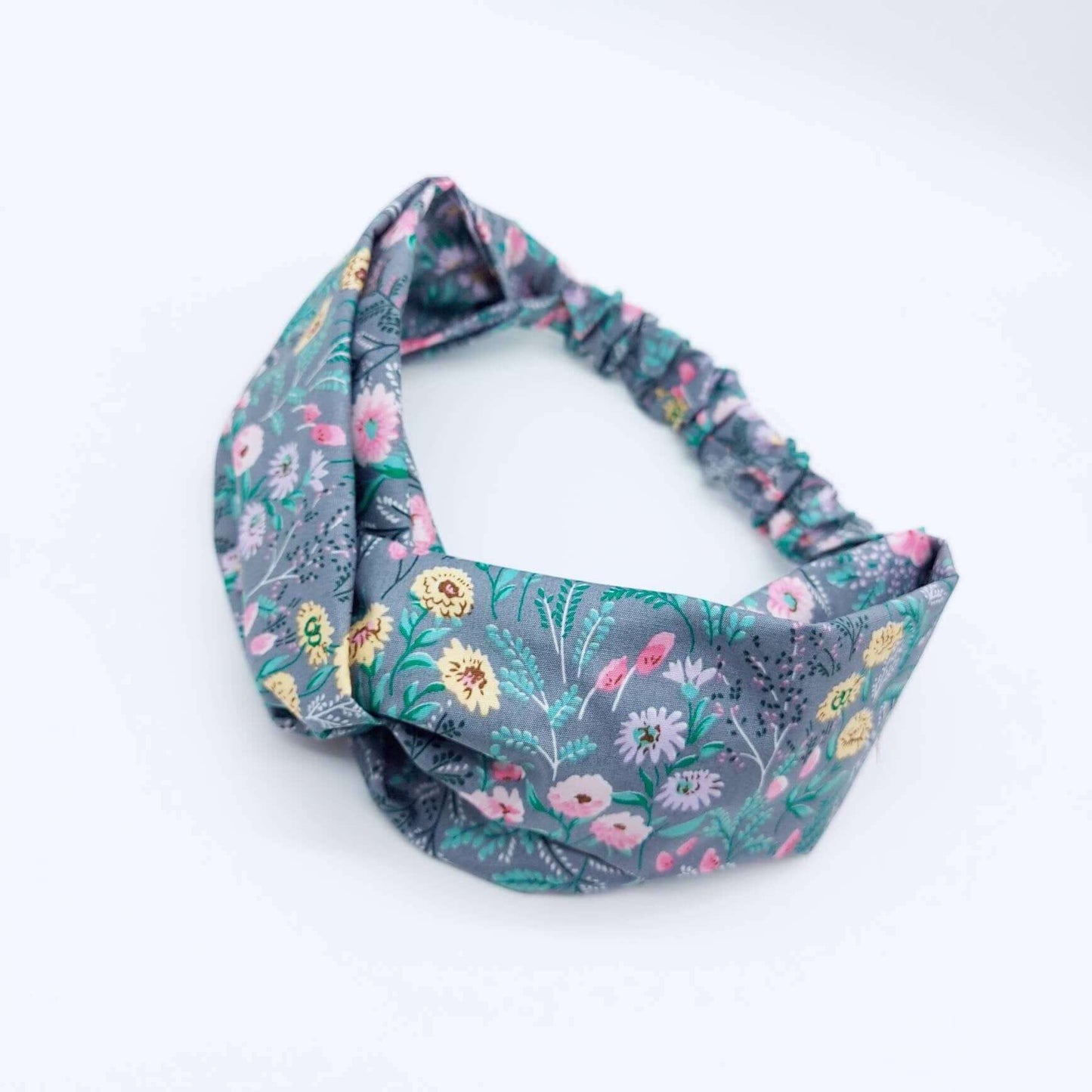 A pretty grey cotton, ditsy floral print turban twist headband with an elasticated panel at the back.