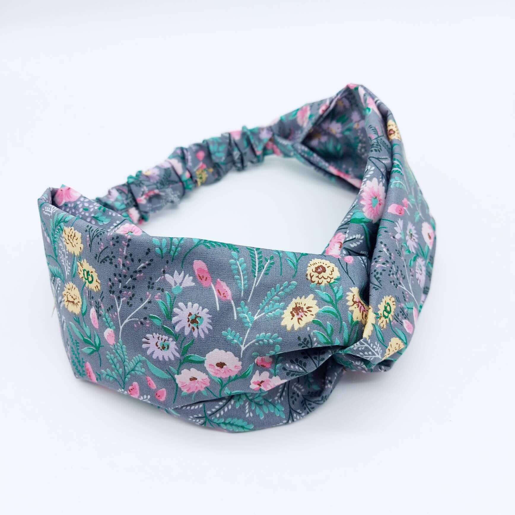 A pretty grey cotton, ditsy floral print turban twist headband with an elasticated panel at the back.