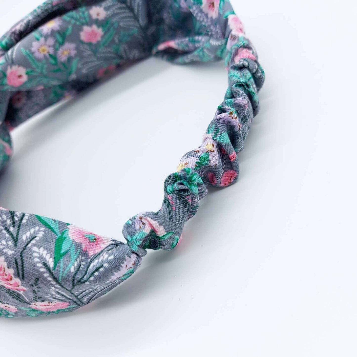 A pretty grey cotton, ditsy floral print turban twist headband with an elasticated panel at the back.