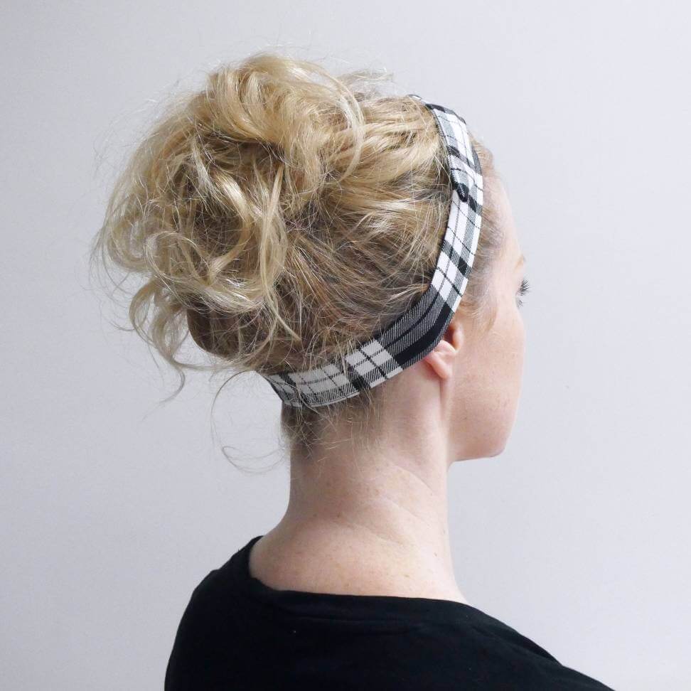 Model wears a tartan plaid, monochrome, black and white fabric, tie headband, tied in a pretty knot.