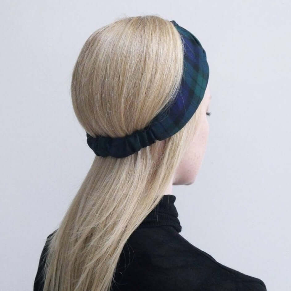 Model wears a soft, black and blue plaid tartan check, elasticated fabric headband, with a turban twist design at the front.