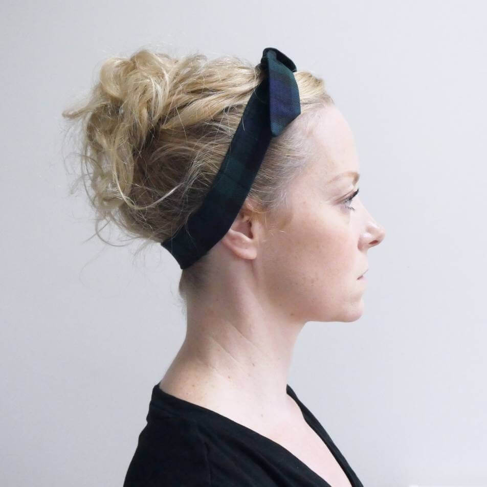 Model wears a black and navy blue tartan check fabric, tie headband, tied in a pretty knot.