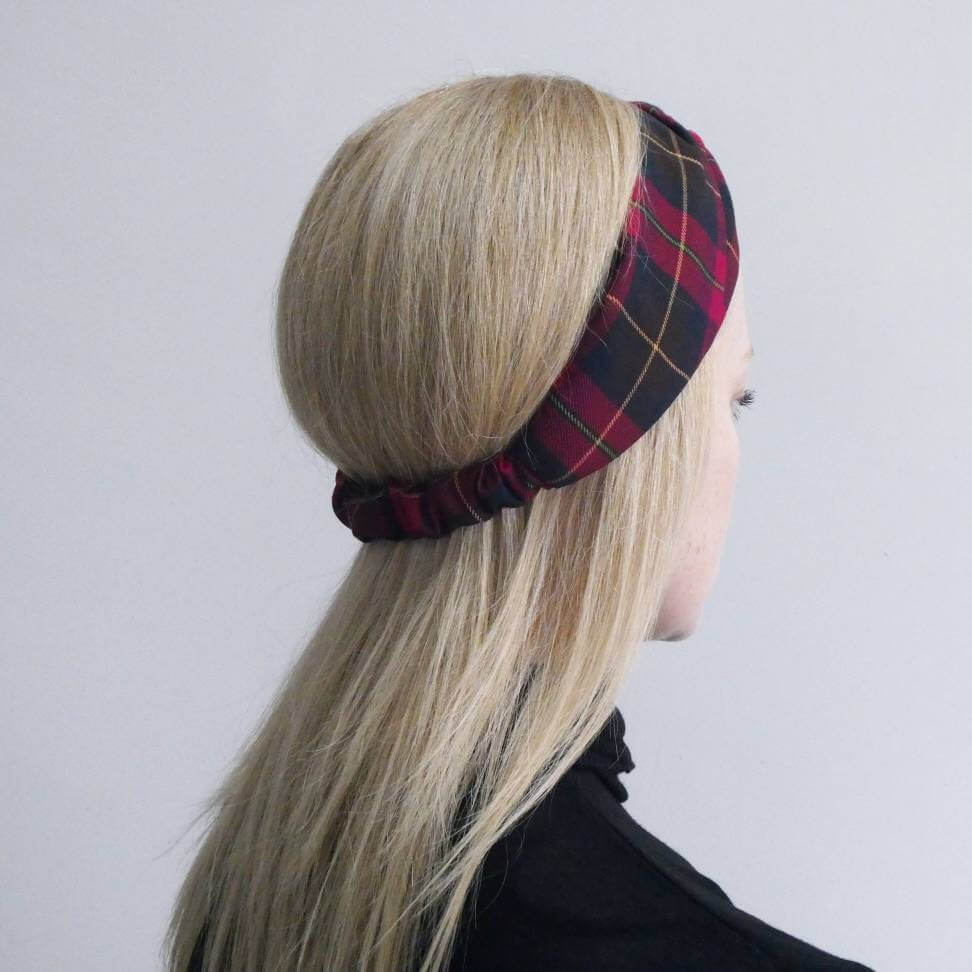 Model wears a soft, cranberry red, tartan, plaid, check, elasticated fabric turban twist headband.