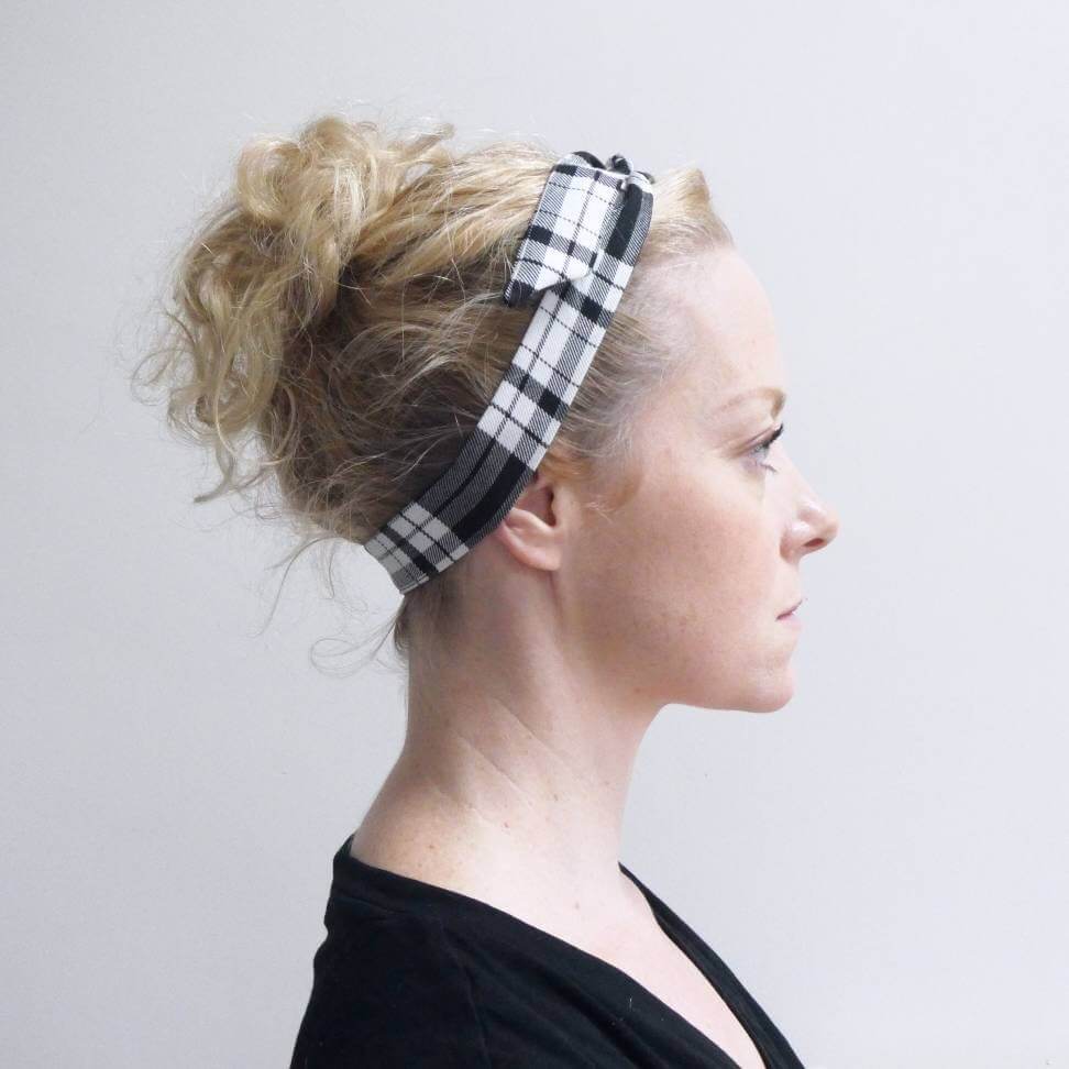Model wears a tartan plaid, monochrome, black and white fabric, tie headband, tied in a pretty knot.