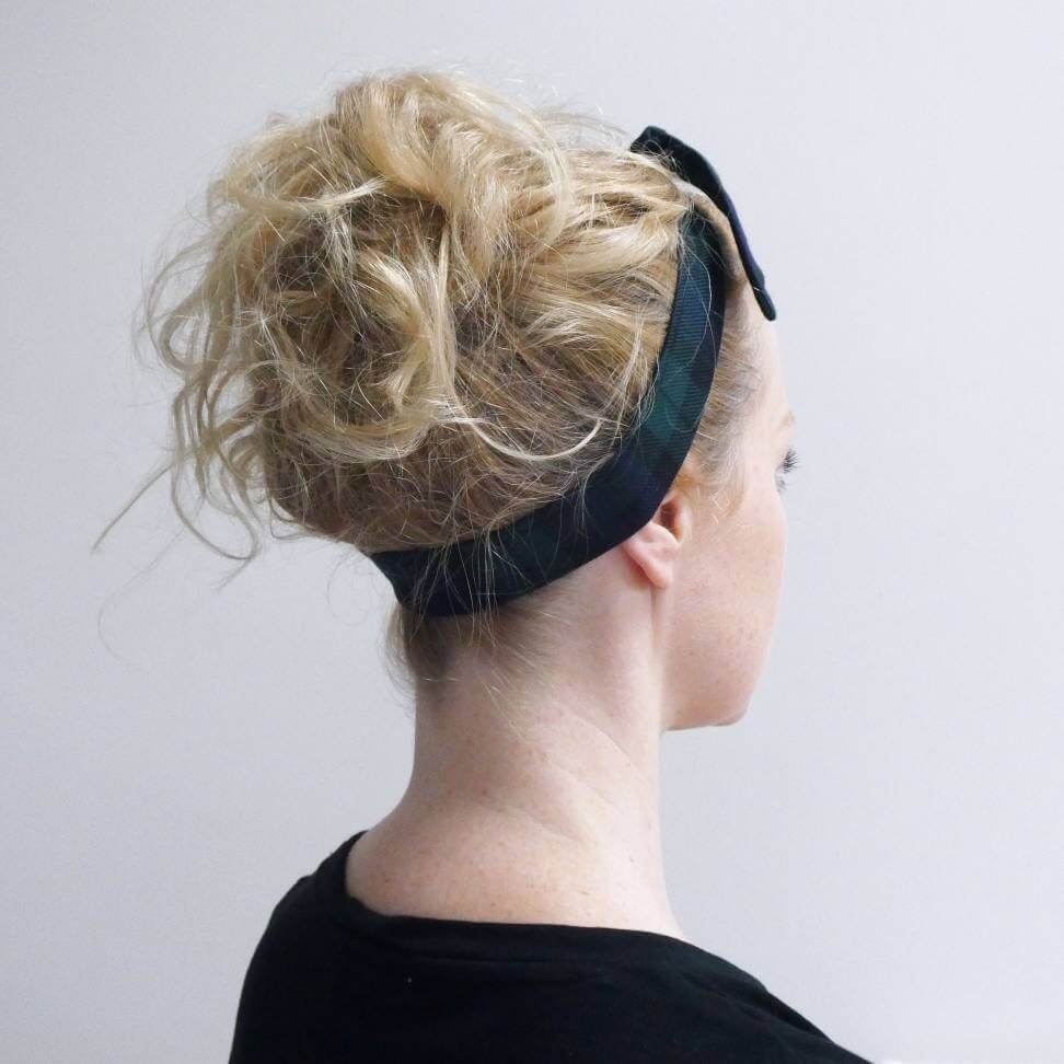 Model wears a black and navy blue tartan check fabric, tie headband, tied in a pretty knot.