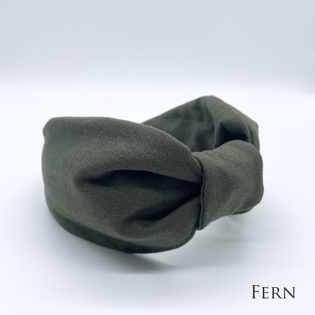 A fern green linen knotted headband in a bow style.