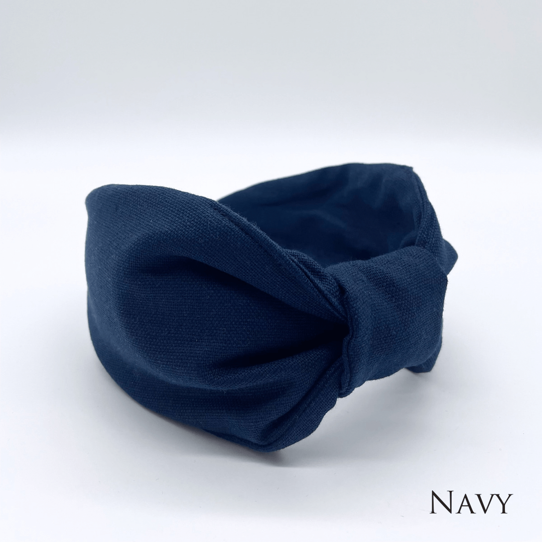 A navy linen knotted headband in a bow style.