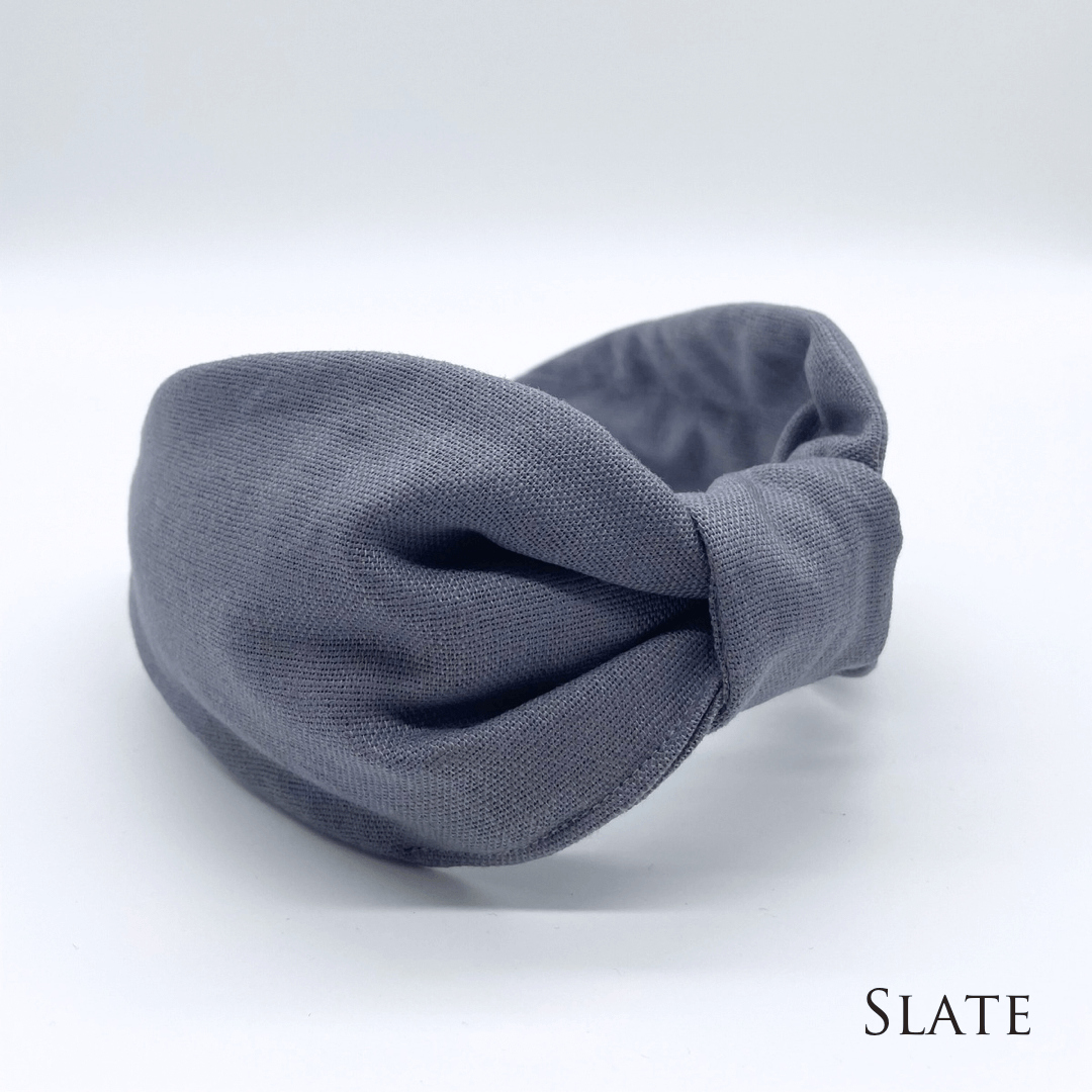 A slate linen knotted headband in a bow style.
