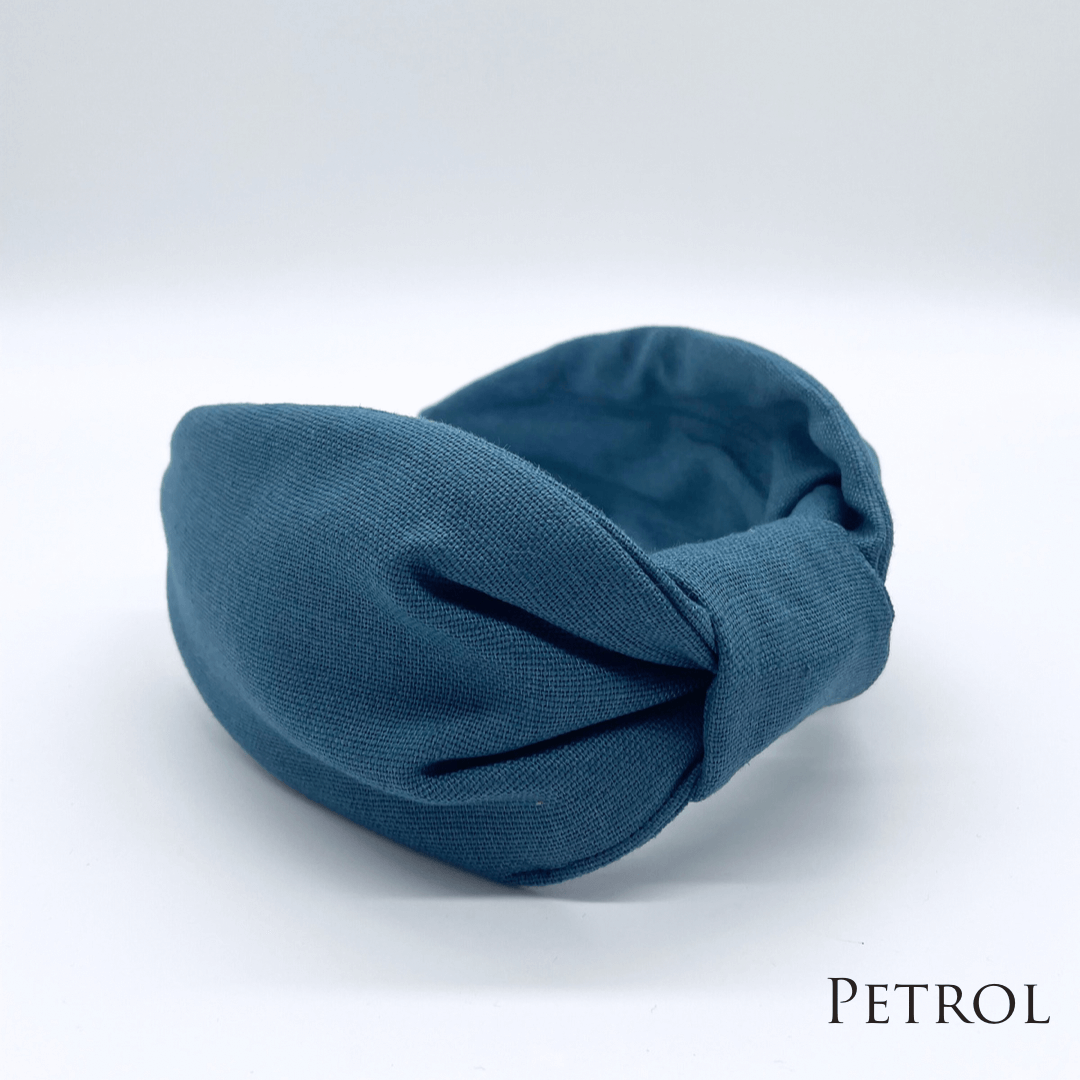 A petrol linen knotted headband in a bow style.