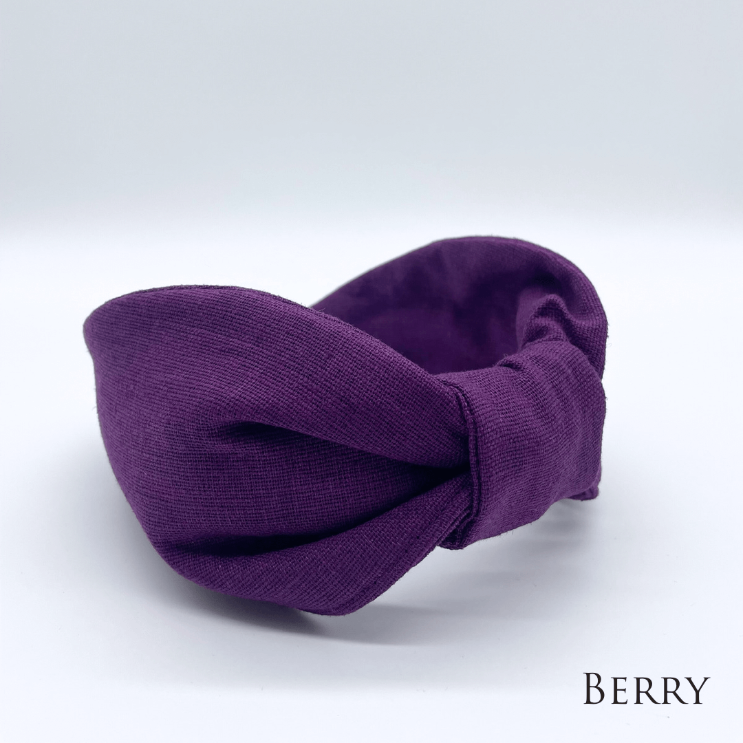 A berry linen knotted headband in a bow style.