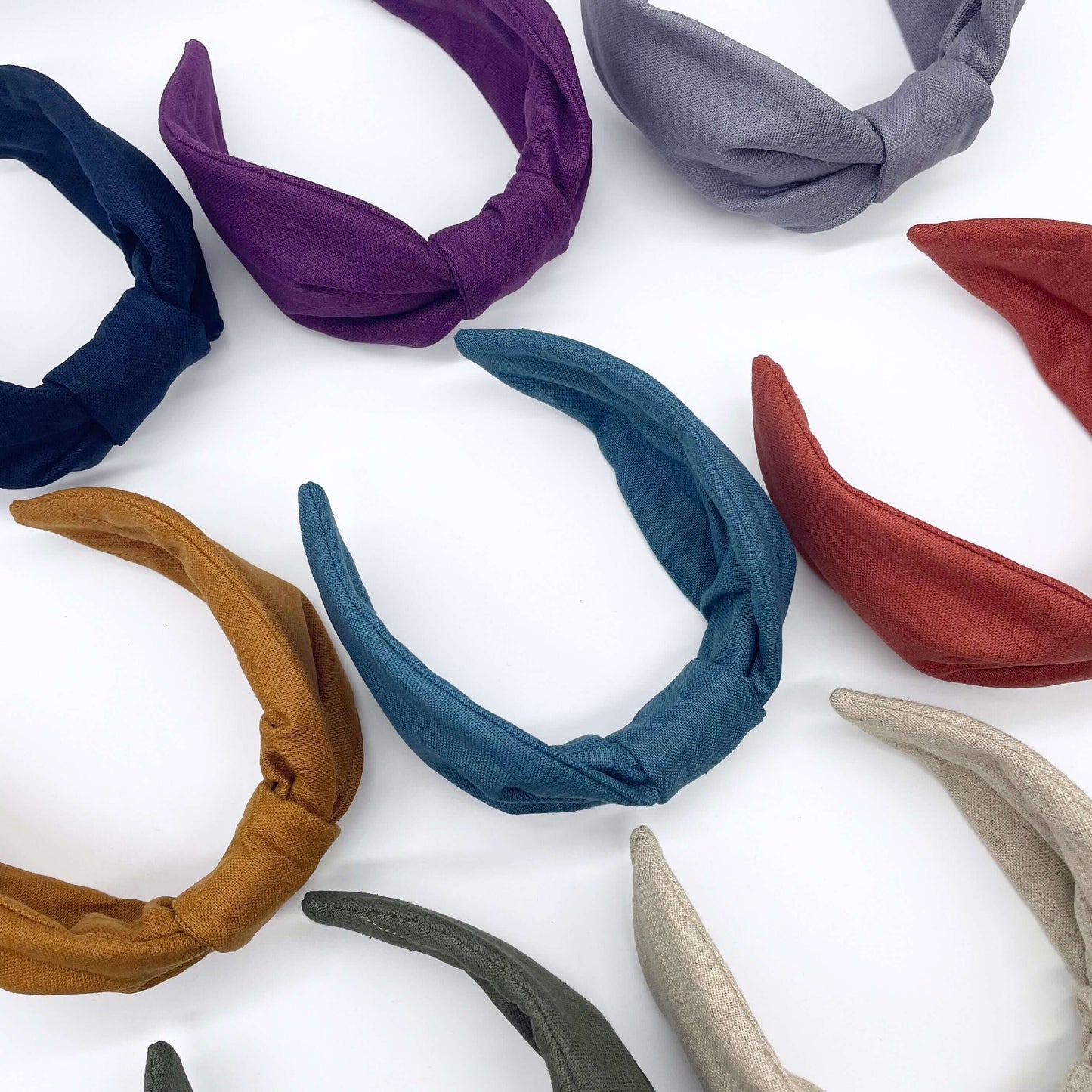 A group of plain linen knotted headbands in bright bold colours.