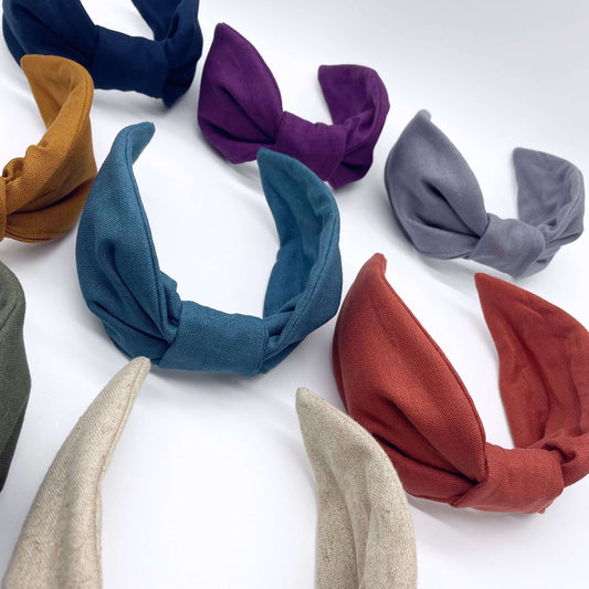 A group of plain linen knotted headbands in bright bold colours.