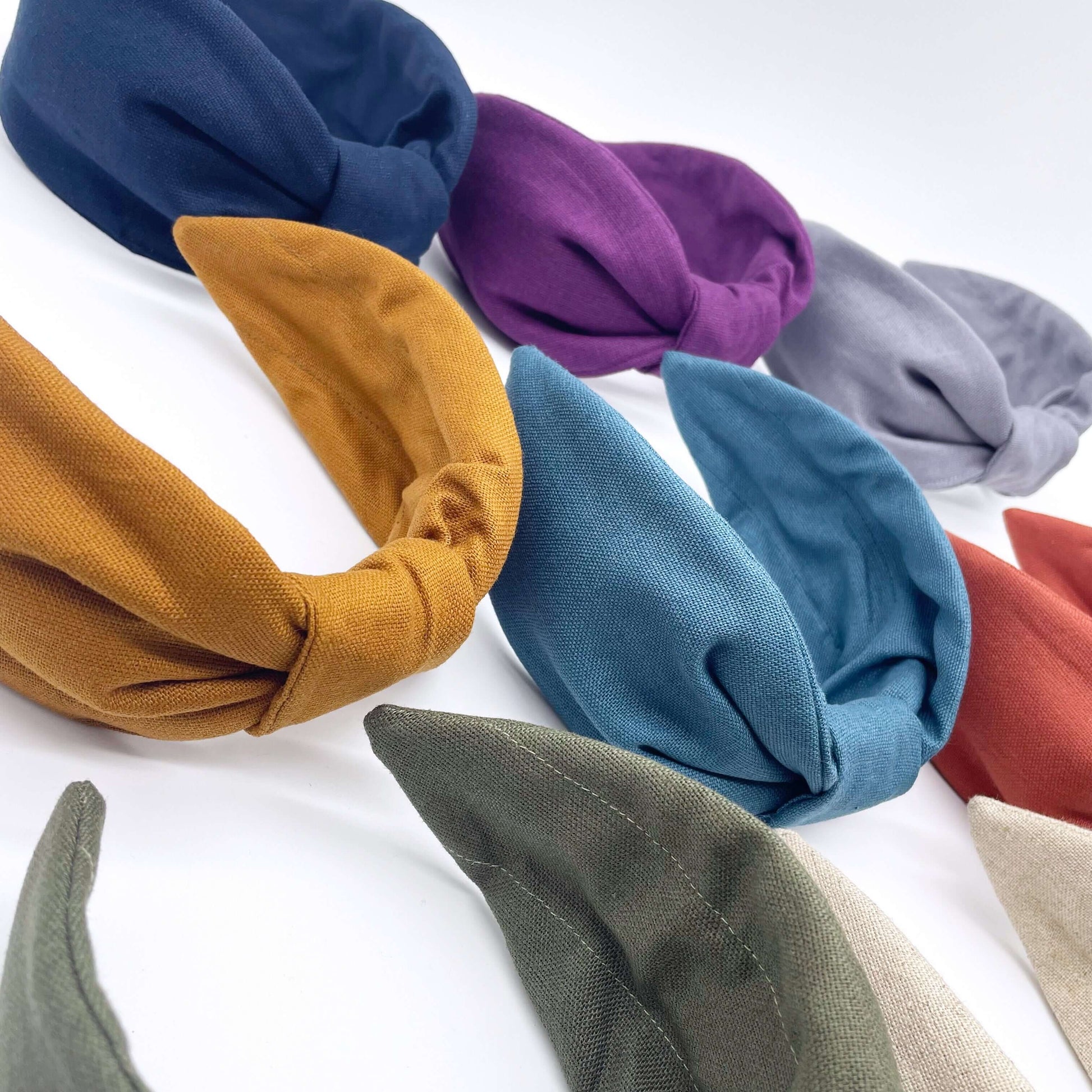 A group of plain linen knotted headbands in bright bold colours.