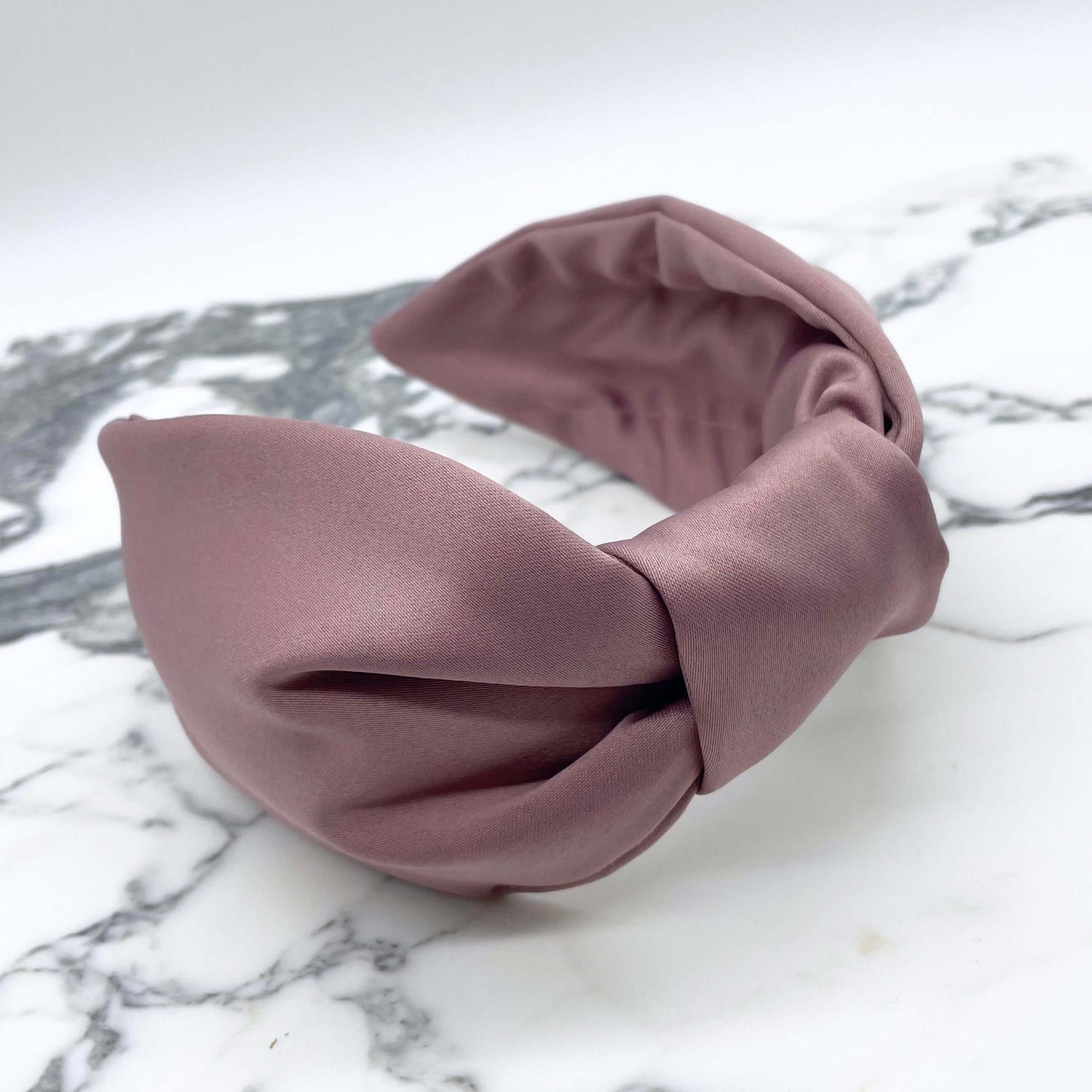 Rose pink satin knotted headband in a bow style