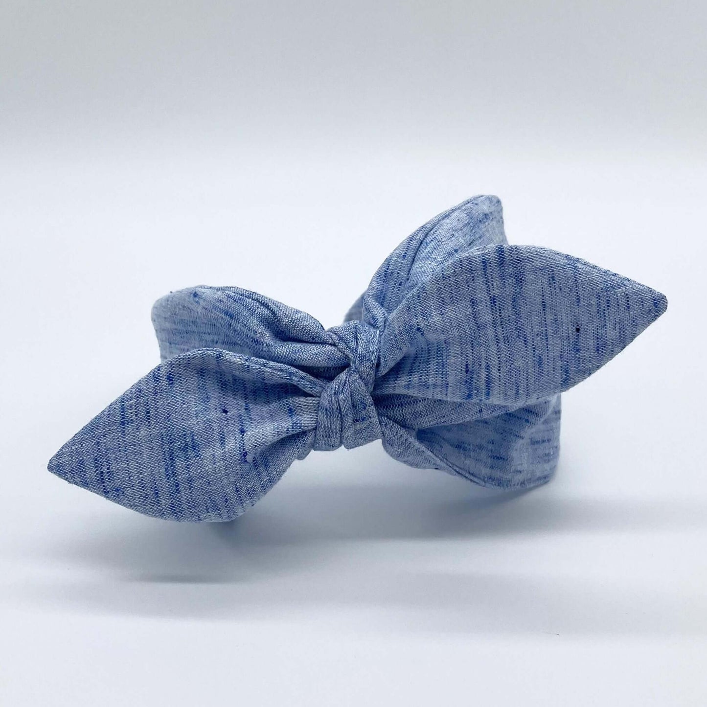 A blue coloured linen headban with a bow.