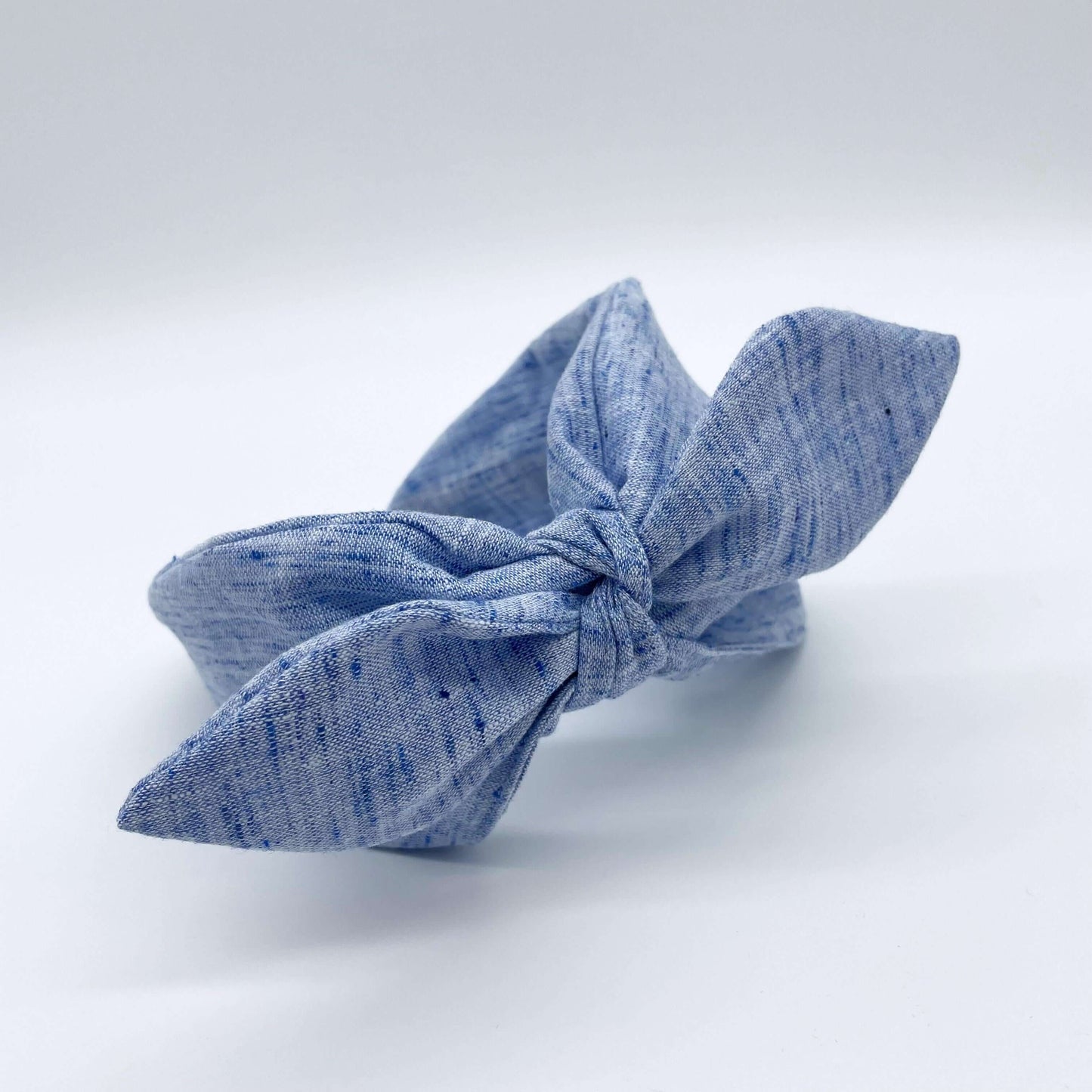 A blue coloured linen headban with a bow.