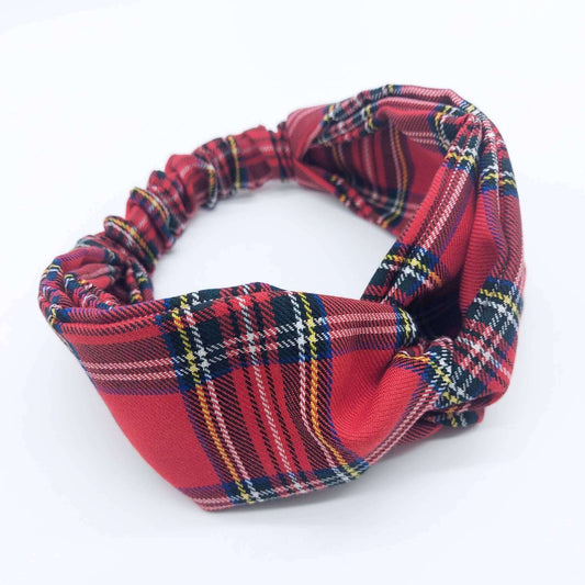 A soft, red traditional tartan, plaid, check, elasticated fabric headband, with a turban twist design at the front.
