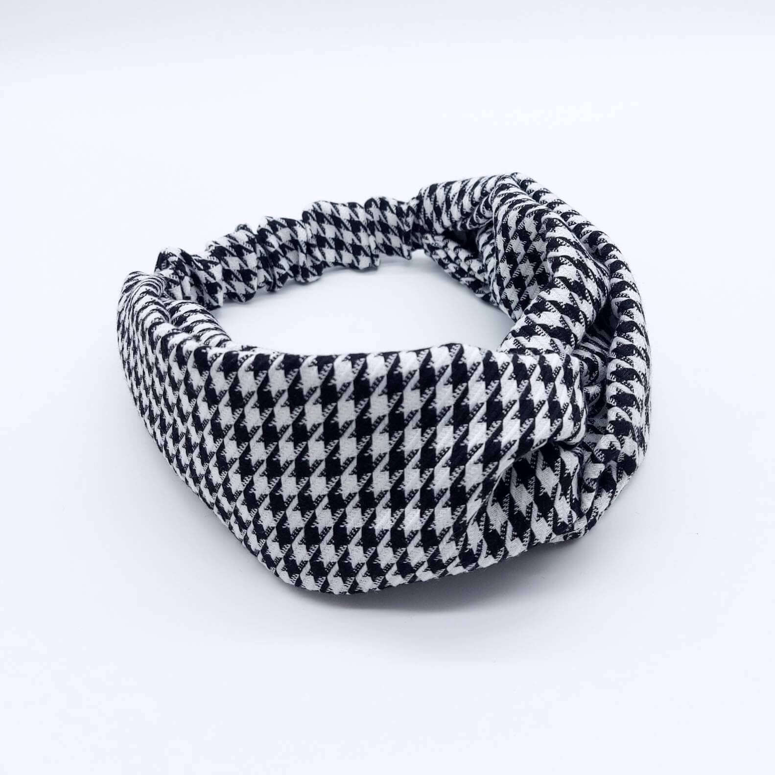 A luxurious, elasticated, turban twist headband made from a classic, houndstooth, black and white fabric.