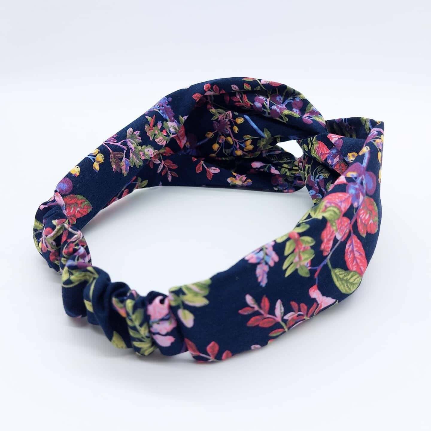 A pretty navy blue cotton, floral print turban twist headband with an elasticated panel at the back.