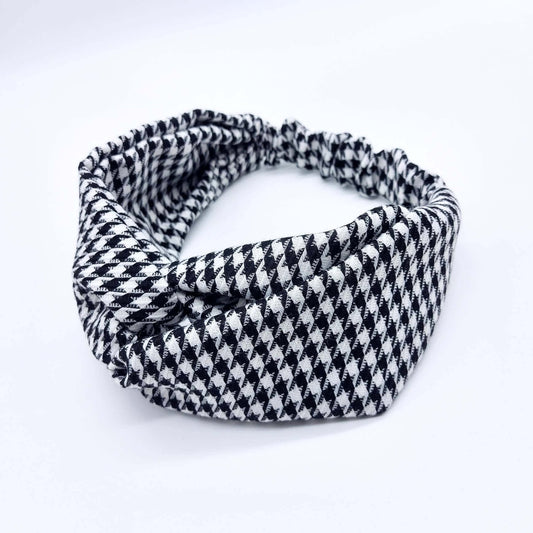A luxurious, elasticated, turban twist headband made from a classic, houndstooth, black and white fabric.