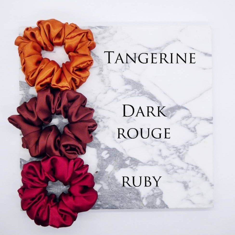 Three luxury large satin hair scrunchies in tangerine, dark rouge and ruby.
