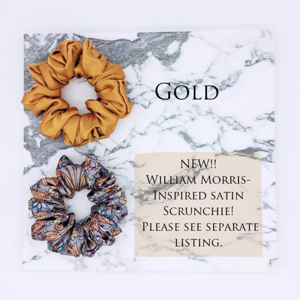 Two large satin hair scrunchies in gold and and a William-Morris-inspired patterned satin in grey.