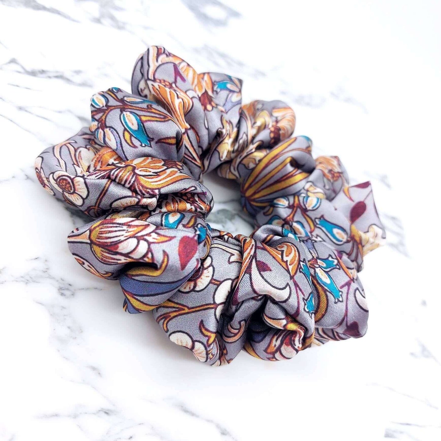 A beautiful grey, William Morris-inspired, patterned satin scrunchie with lots of ruffles.
