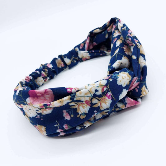 A soft, navy floral, turban twist headband with pops of pink, cream and yellow.