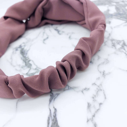 A soft, pale rose, viscose, elasticated turban twist headband.