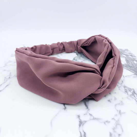 A soft, pale rose, viscose, elasticated turban twist headband.