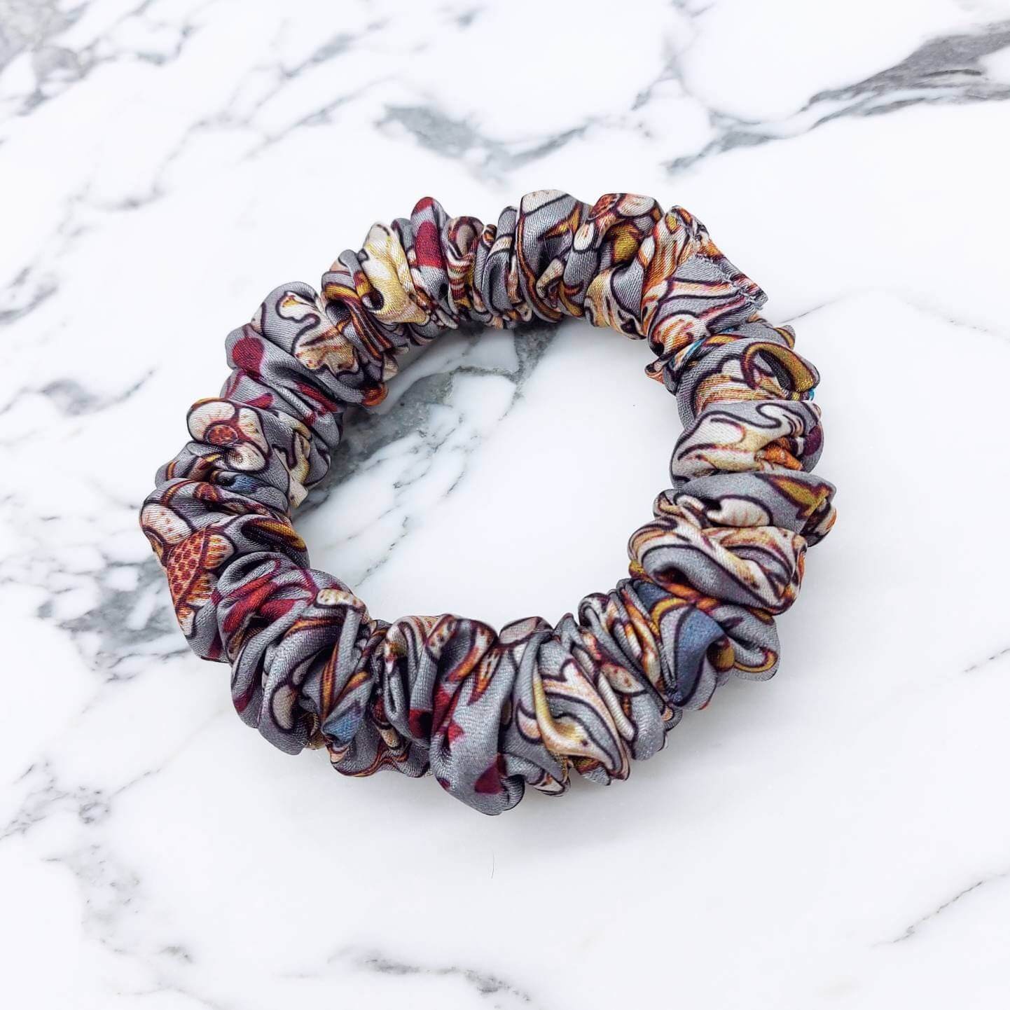 A skinny, beautiful grey, William Morris-inspired, patterned satin scrunchie.