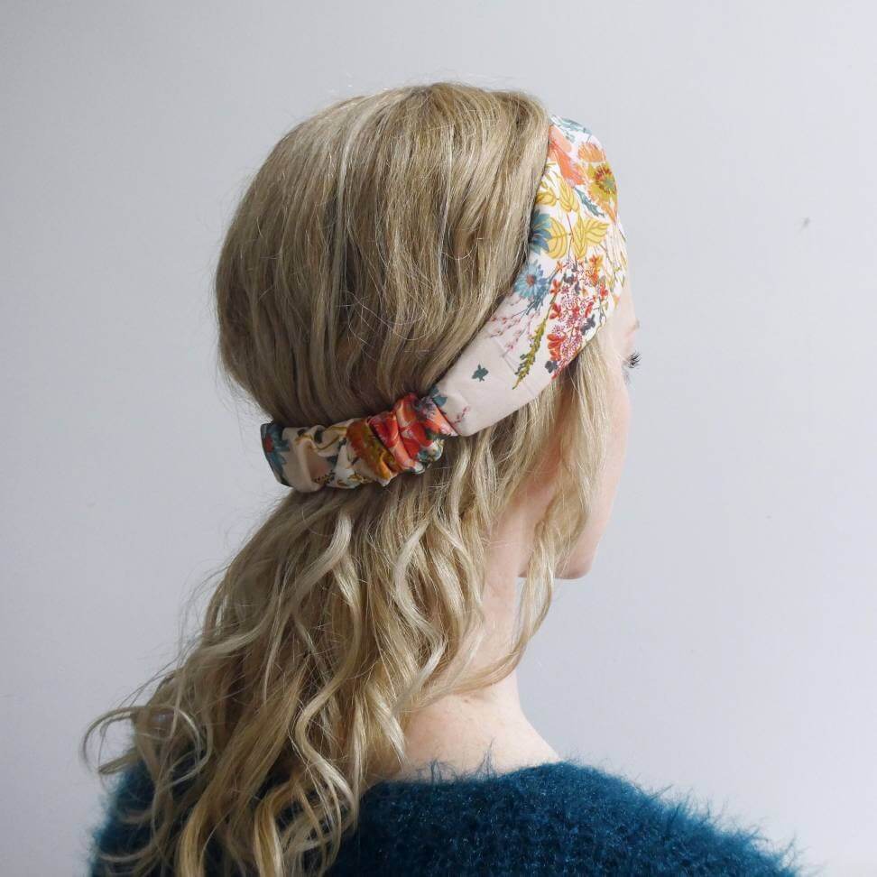 Model wears A pretty cream cotton, floral print turban twist headband with an elasticated panel at the back.