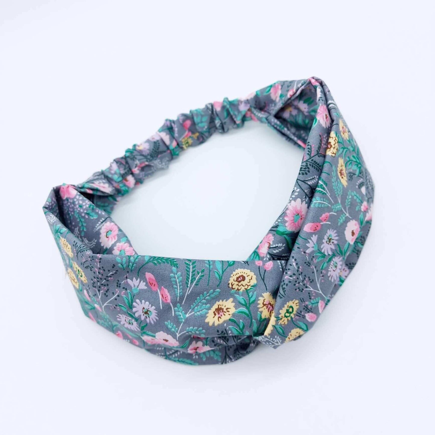 A pretty grey cotton, ditsy floral print turban twist headband with an elasticated panel at the back.