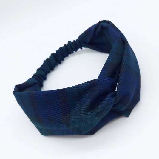 A soft, black and blue plaid tartan check, elasticated fabric headband, with a turban twist design at the front.