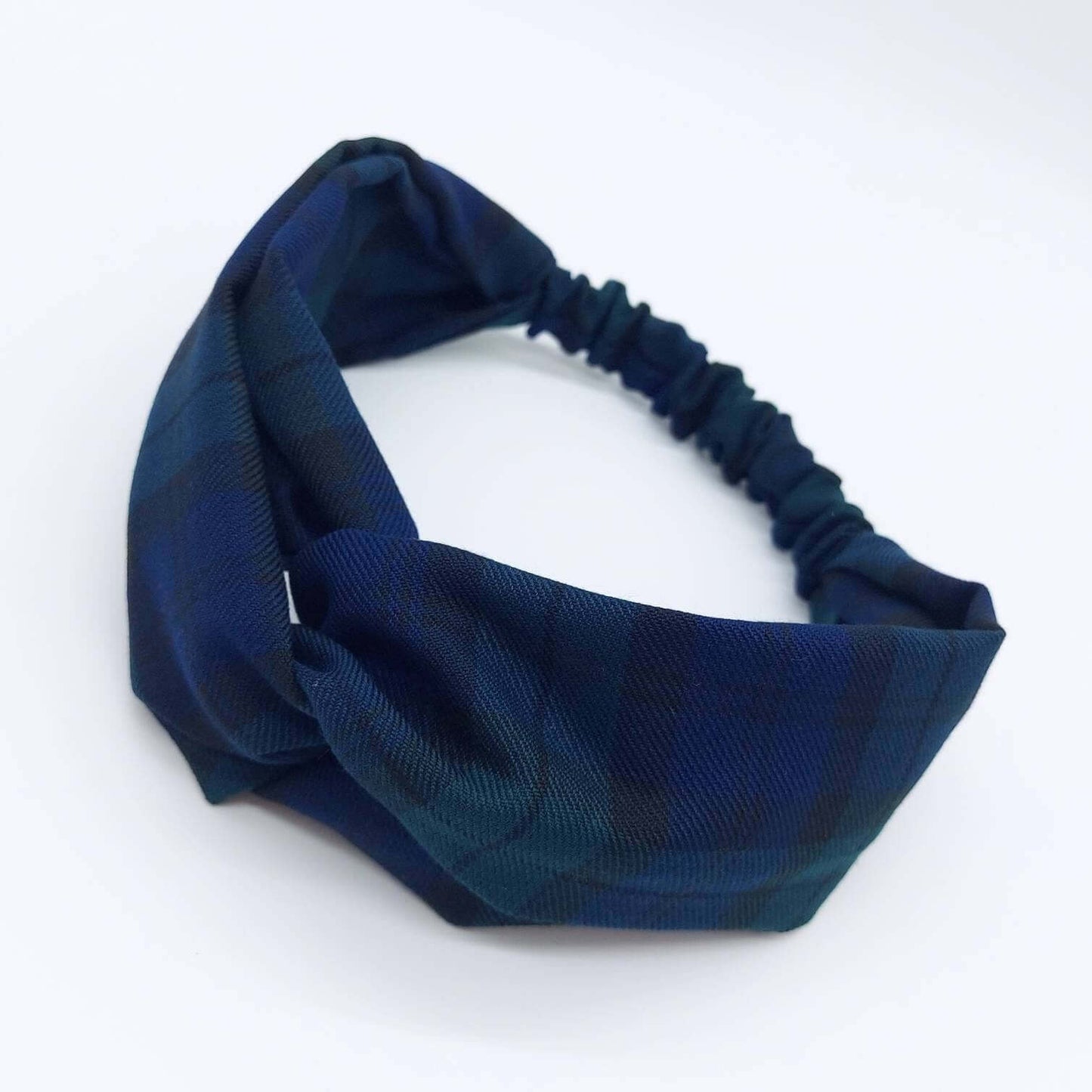A soft, black and blue plaid tartan check, elasticated fabric headband, with a turban twist design at the front.