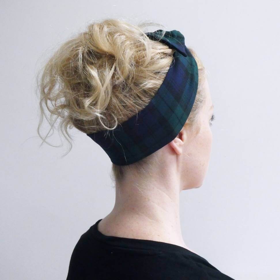 Model wears a black and navy blue tartan check fabric, tie headband, tied in a pretty knot.