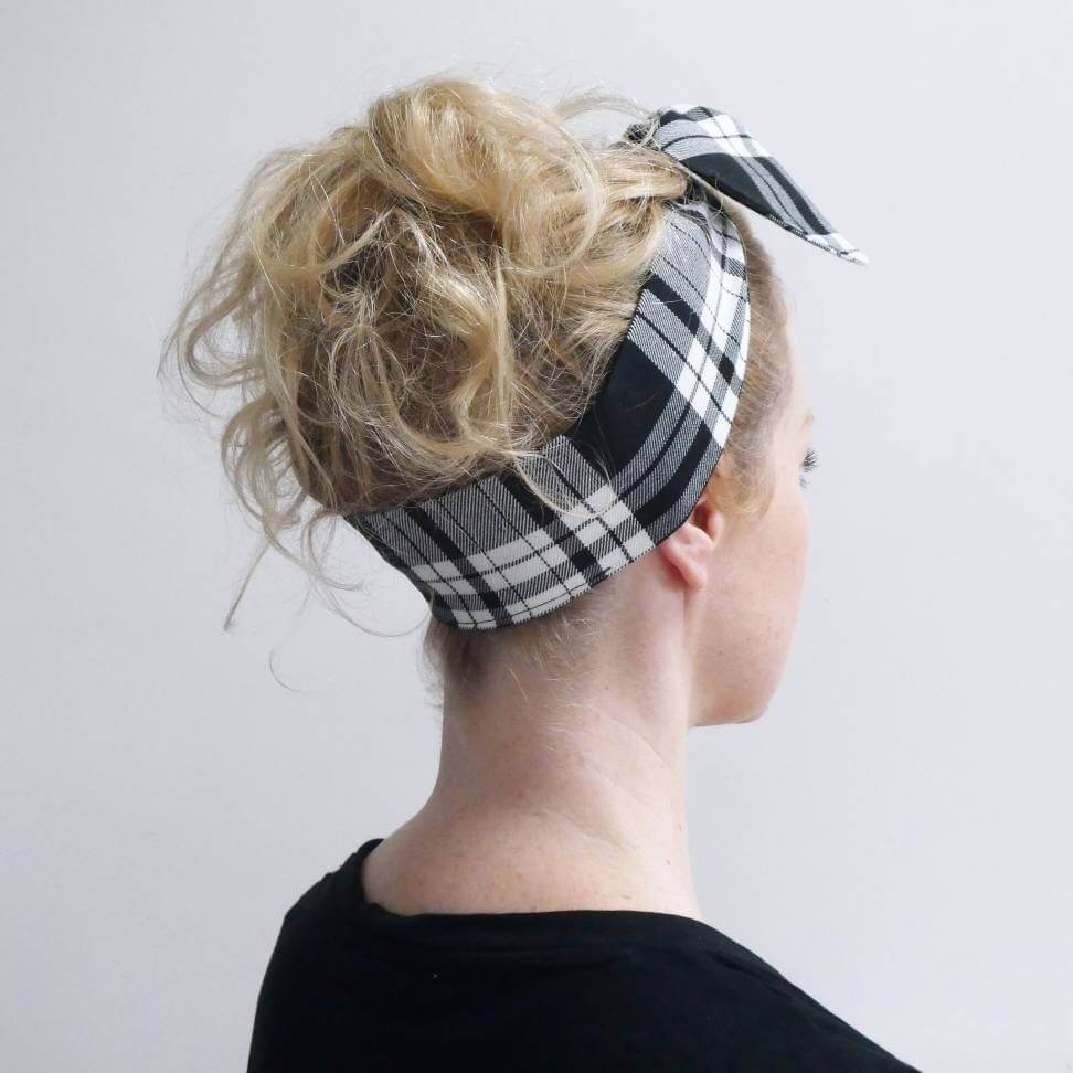 Model wears a tartan plaid, monochrome, black and white fabric, tie headband, tied in a pretty knot.