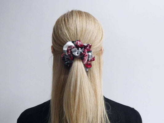 Model wears her hair in a half-up ponytail, using a red and white tartan plaid hair scrunchie.
