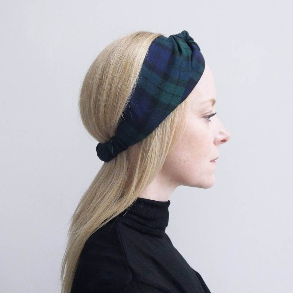 Model wears a soft, black and blue plaid tartan check, elasticated fabric headband, with a turban twist design at the front.
