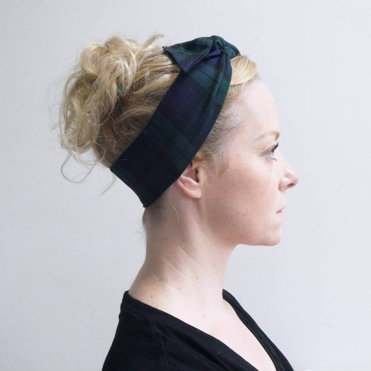 Model wears a black and navy blue tartan check fabric, tie headband, tied in a pretty knot.