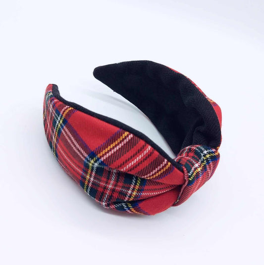A bow-style, black and red tartan paid fabric knot headband with plain black lining underneath.