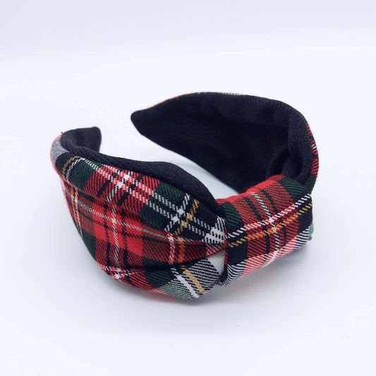 A bow-style, black and red tartan plaid fabric headband with plain black lining underneath.