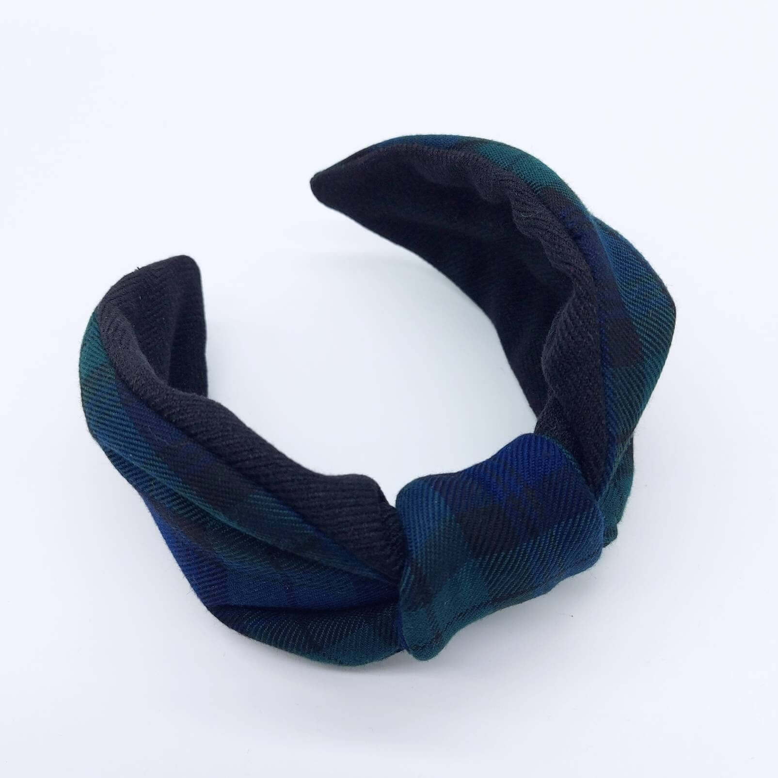 A bow-style, black and navy blue tartan plaid fabric headband with plain black lining underneath.