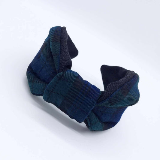 A bow-style, black and navy blue tartan plaid fabric headband with plain black lining underneath.